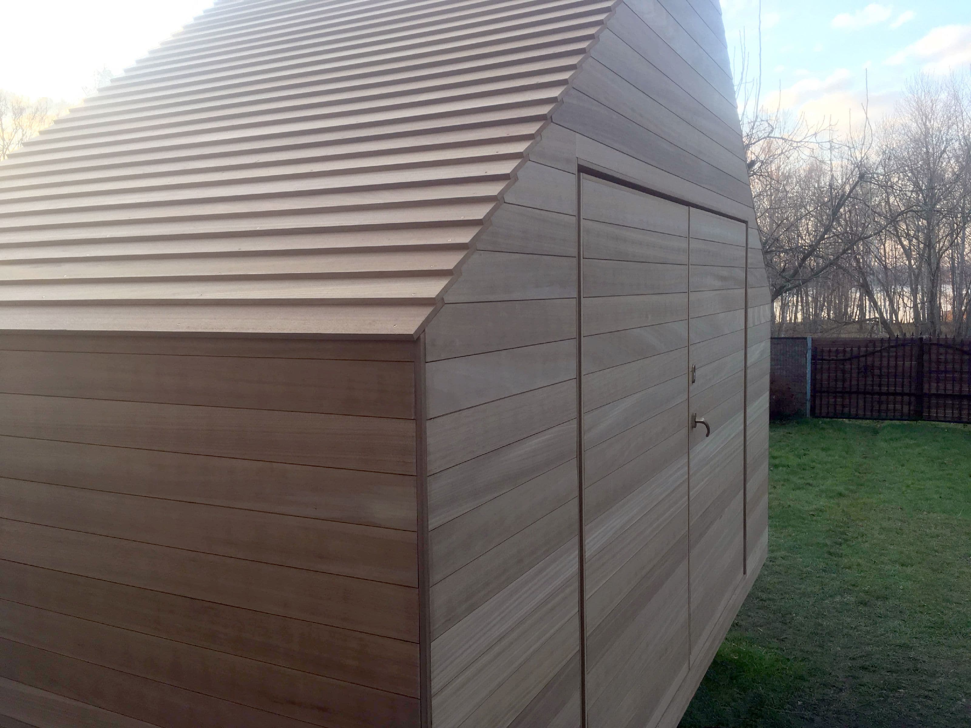 Monolithic wooden house, uniform, fitting into the landscape, house from nature, window like a frame frames nature